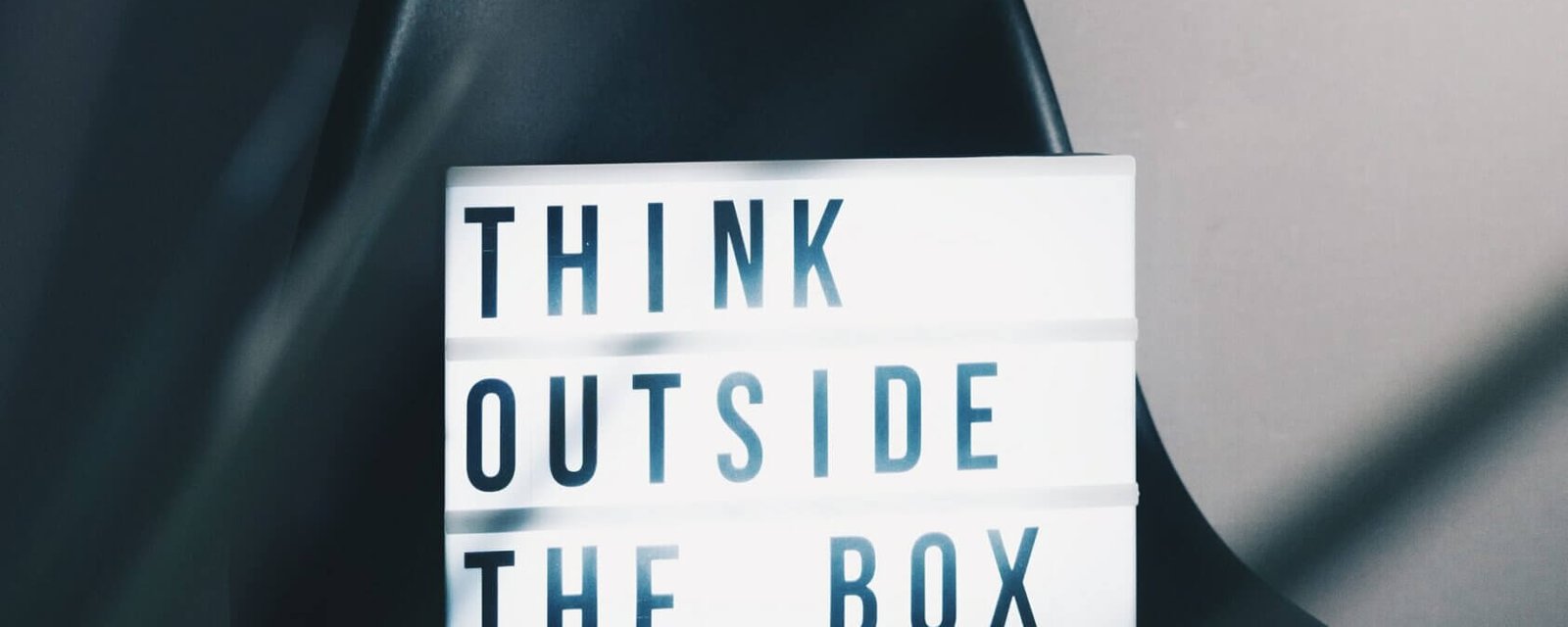 A sign reading "Think Outside The Box" on a chair